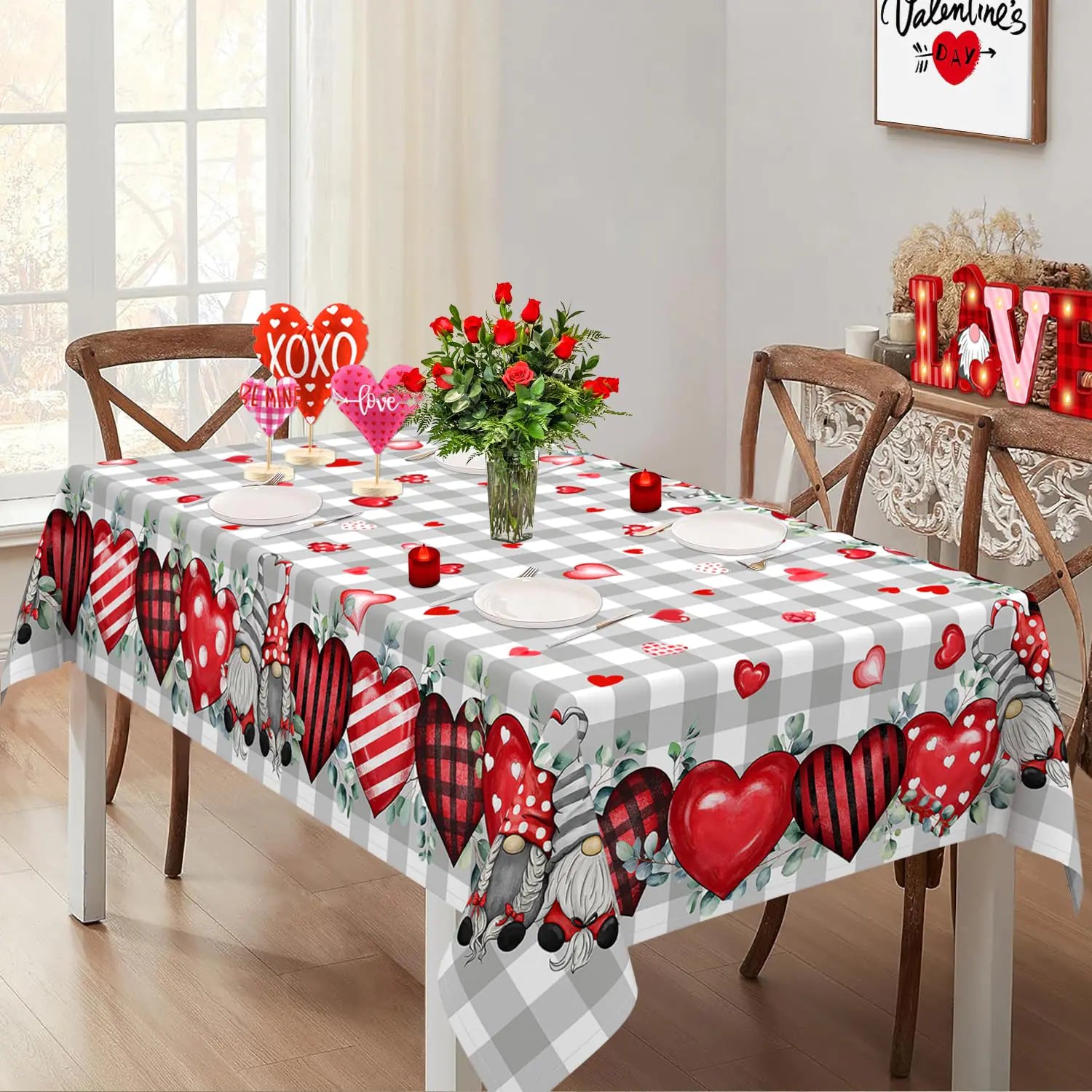 Dining table set with a Valentine's Day-themed tablecloth featuring hearts and gnomes.