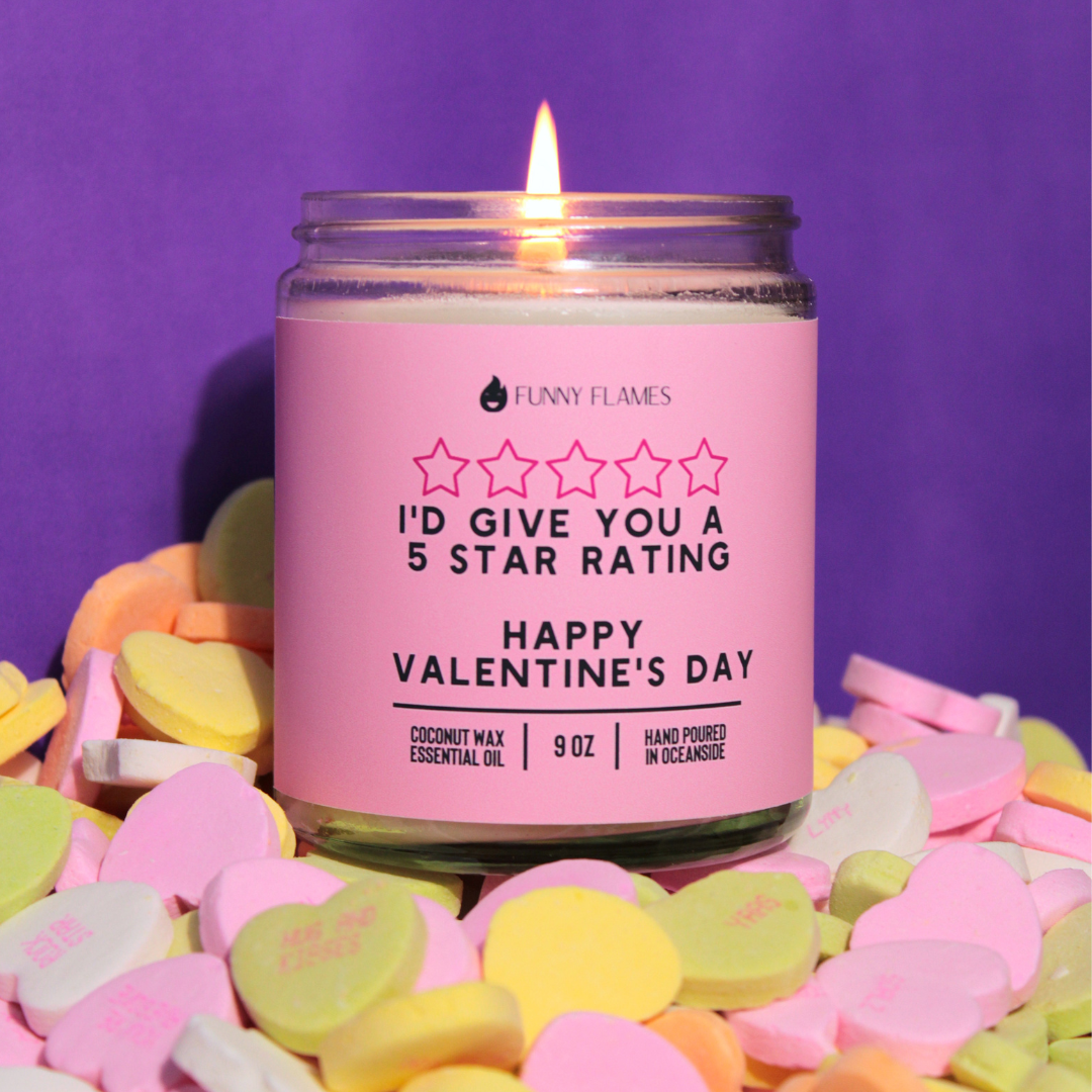 Candle with a pink label on Valentine's Day, surrounded by colorful heart-shaped candy against a purple background.