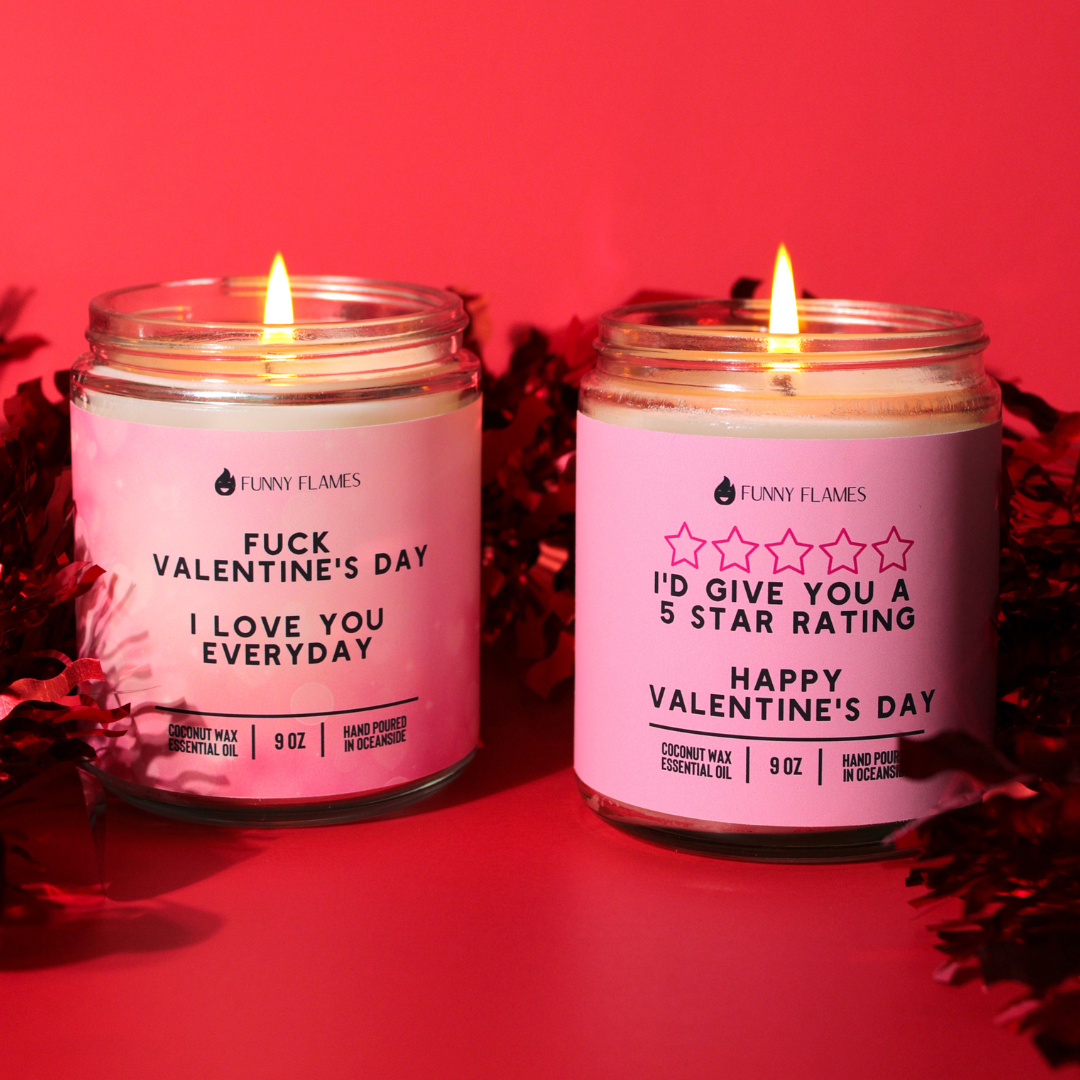 Two lit candles with pink labels on a red background